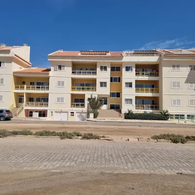 a large apartment building in front of a parking lot at A1-5101- 3 Bedroom Seaview Apartment in Cape Verde in Sal Rei