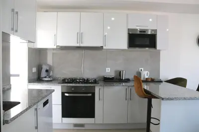 a kitchen with white cabinets and a stove top oven at Alto in Mindelo