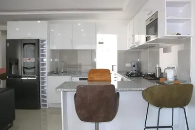 a kitchen with white cabinets and a black refrigerator at Alto in Mindelo