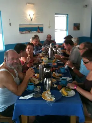 a group of people sitting at a table eating food at Djabraba's Boarding Rooms in Garça