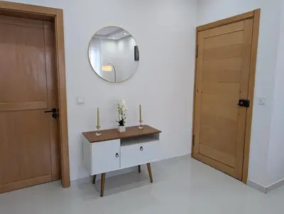 a bathroom with a vanity and a mirror and a door at Modern and Stylish 1BR Apt - Cidadela - Ground Floor in Praia