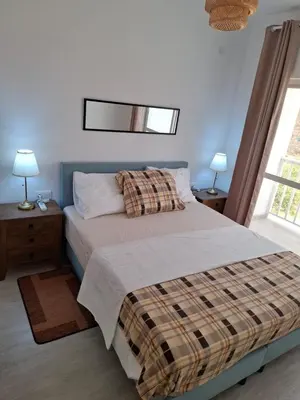 a bedroom with a bed and two lamps and a window at Apartamentos Fatynybal in Espargos