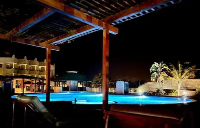 a swimming pool at night with a pergola at Tropical Oceano in Santa Maria