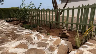 a garden with a fence and some rocks at Bougainvillea Villa in Cidade Velha