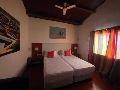a bedroom with a large bed and a window at Bougainvillea Villa in Cidade Velha