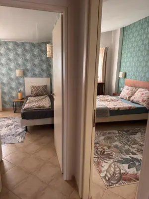 a bedroom with two beds and a doorway to a room at Tropical Anzso in Santa Maria