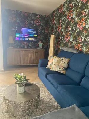 a living room with a blue couch and a table at Tropical Anzso in Santa Maria