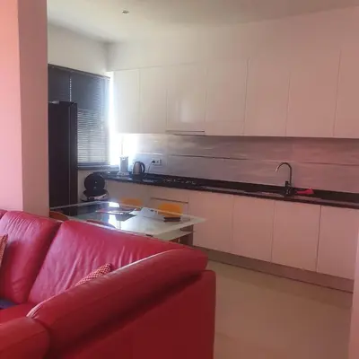 a living room with a red couch and a kitchen at 3-bedroom Apartment Praia Santiago in Praia