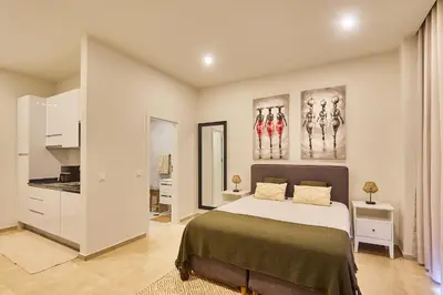 a bedroom with a large bed and a kitchen at Terra Boa beach apartment Sal Cabo Verde in Santa Maria