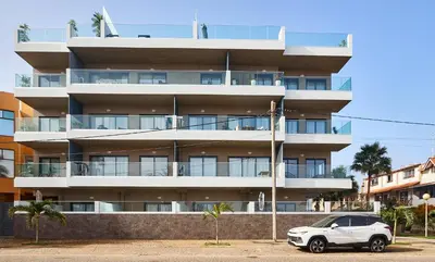 a white car parked in front of a building at Terra Boa beach apartment Sal Cabo Verde in Santa Maria