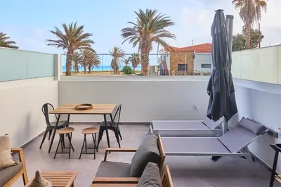 a balcony with a table and chairs and an umbrella at Terra Boa beach apartment Sal Cabo Verde in Santa Maria