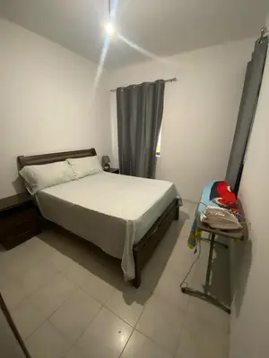 a bedroom with a bed and a backpack in it at Cozy Apartment, 3 Bedrooms in Praia