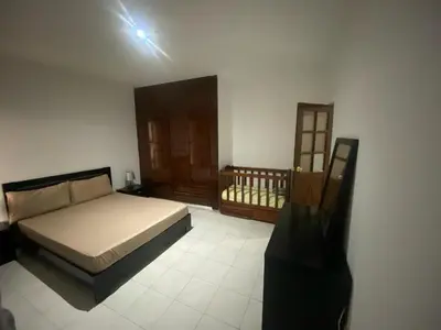 a bedroom with a bed and a wooden door at Cozy Apartment, 3 Bedrooms in Praia