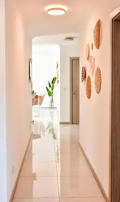 a hallway with white walls and a tile floor with hearts on the wall at Gorgeous 3-bdr apt - 1-min laginha beach - LCGR in Mindelo