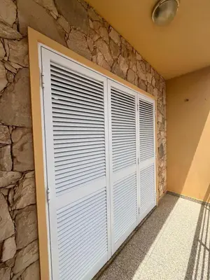 a garage with white doors and a stone wall at Casa di Mar in Santa Maria