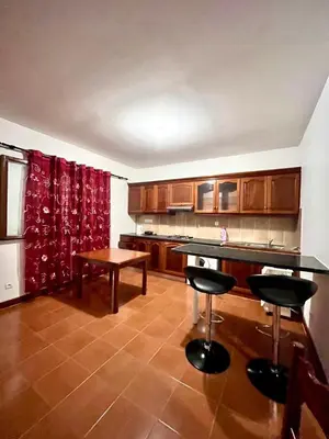 a kitchen with two bar stools and a table at Casa BB&Djassi - Apartment T1 in Ponta do Sol