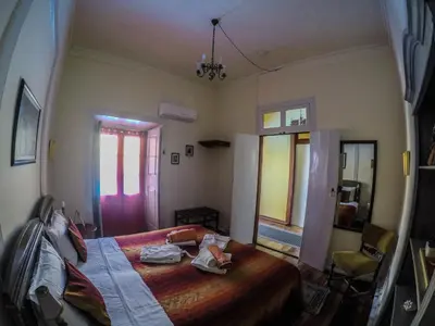 a bedroom with a bed and a room with a window at The Colonial Guest House in São Filipe