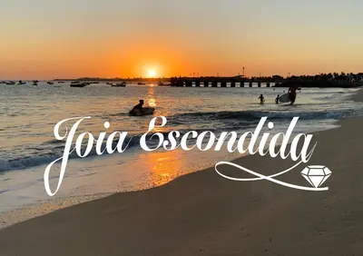 a sunset on the beach with the words tuva escondida at Joia Escondida in Santa Maria