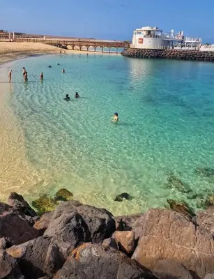a group of people in the water at a beach at Cosy 2 Bed Apartment Vila Verde Santa Maria in Santa Maria