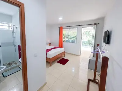 a bedroom with a bed and a television in a room at Residencial Mãe Nona in Ribeira Grande