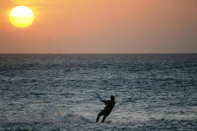 a man kite surfing in the ocean at sunset at Endless Summer B6 in Sal Rei