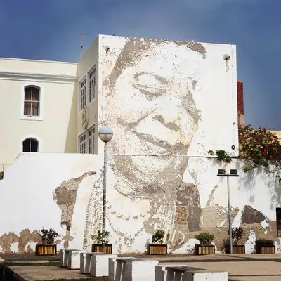 a large mural of a face on the side of a building at Mindelo Bay Apartment in Mindelo