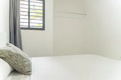 a bed with a pillow next to a window at 3-bdr apt 10-min walk laginha beach - LCGR in Mindelo