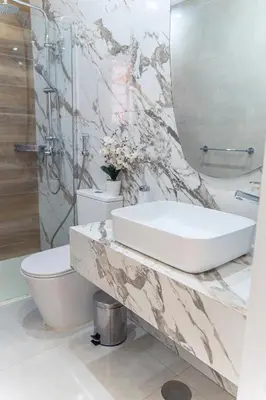 a bathroom with a sink and a toilet and a mirror at 3-bdr apt 10-min walk laginha beach - LCGR in Mindelo