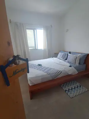 a bedroom with a bed with white sheets and a window at Sinagoga Guesthouse in Ribeira Grande