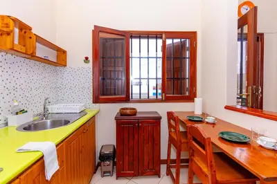 a kitchen with a sink and a wooden table at T1 - 800m from the beach - located in the city center in Santa Maria