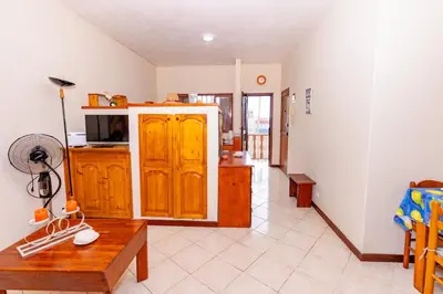 a living room with a wooden cabinet and a table at T1 - 800m from the beach - located in the city center in Santa Maria