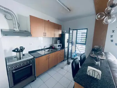 a kitchen with a sink and a stove top oven at APPARTEMENT IDEAL POUR ESCALE a PRAIA in Praia