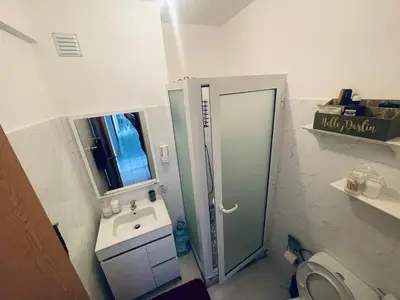 a small bathroom with a shower and a sink at APPARTEMENT IDEAL POUR ESCALE a PRAIA in Praia