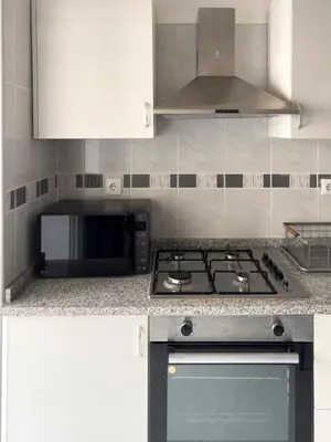 a kitchen with a stove and a microwave at 3 bdr cozy apt, Exterior POOL , Cidadela - LCGR in Praia