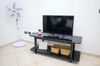 a flat screen tv sitting on top of a table at 1 bedroom apartment with sofa bed 4 min walk from the beach in Santa Maria