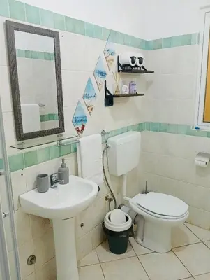 a bathroom with a toilet and a sink at 1 bedroom apartment with sofa bed 4 min walk from the beach in Santa Maria