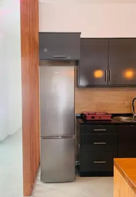 a kitchen with a stainless steel refrigerator and black cabinets at NOBRE LUZ T2 Boa Vista in Sal Rei