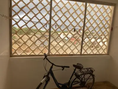a bike parked in a room with a window at Prédio IFH Maio in Vila do Maio