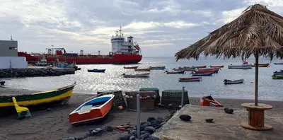 a large boat in the water with many boats at Studio Alto Saco in Tarrafal
