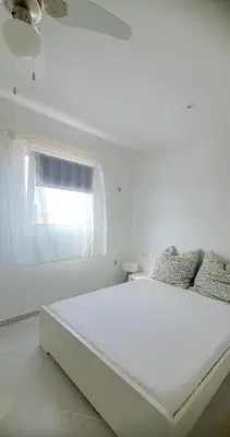 a white bedroom with a large bed with a window at Residência Alto Saco, Double room with private bathroom in Tarrafal