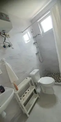 a white bathroom with a toilet and a sink at Residência Alto Saco, Double room with private bathroom in Tarrafal