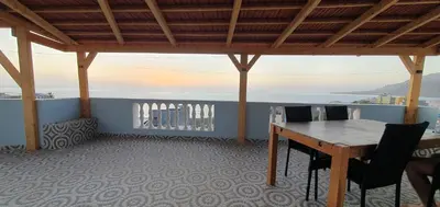 a room with a table and chairs on a balcony at Residência Alto Saco, Double room with private bathroom in Tarrafal