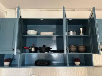 a kitchen with blue cabinets with pots and pans at Plateau- Sea View Apartment in Praia