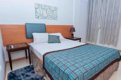 a bedroom with a bed and two tables and a window at Chã de Areia Lounge Vista Mar - Apartamento T2 in Praia