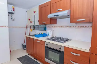 a kitchen with wooden cabinets and a stove top oven at Chã de Areia Lounge Vista Mar - Apartamento T2 in Praia