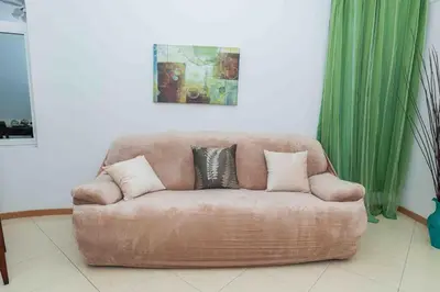 a brown couch with three pillows on it in a living room at Chã de Areia Lounge Vista Mar - Apartamento T2 in Praia
