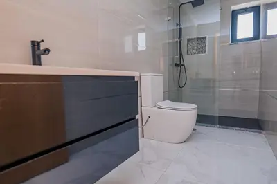 a bathroom with a toilet and a shower and a sink at Otro Residence in Praia