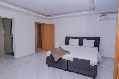 a bedroom with a large bed in a white room at Otro Residence in Praia