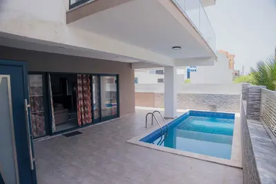 a house with a swimming pool next to a building at Otro Residence in Praia