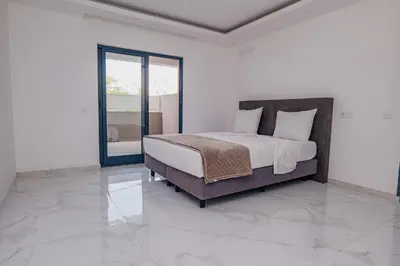 a bedroom with a bed and a glass door at Otro Residence in Praia